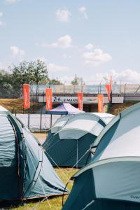 a group of tents are lined up in a field at Bronze - Camping in Le Mans