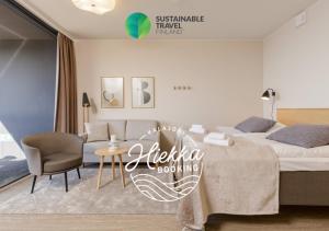 a bedroom with a bed and a table and a couch at Marina Chalets Studios by Hiekka Booking - sisältää liinavaatteet ja loppusiivouksen in Kalajoki