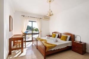 Un dormitorio con una cama y un escritorio y una ventana. en Casa Das Figueiras, en Guia 20 fotos más