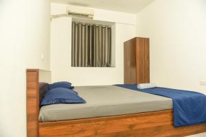 a bedroom with a large bed with blue pillows at Sai Homestay Panaji 2 BHK, 1 BHK and Studio Apartment in Panaji