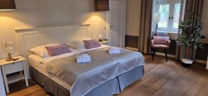 a bedroom with a large bed with towels on it at Schlosshotel Hohenbocka in Hohenbocka