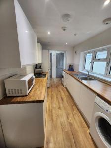 a kitchen with a sink and a microwave on a counter at Manor House walsall 2 in Walsall
