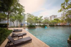 a swimming pool with lounge chairs in a city at Marina Suite with Seafront Sunrise View in George Town