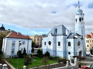 Biały kościół z wieżą zegarową w mieście w obiekcie NEW, BEAUTIFUL APT WITH PARKING IN BEST LOCATION! w Bratysławie