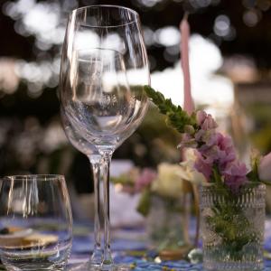 two wine glasses sitting on a table with flowers at Ben's Bed and Breakfast in Pretoria