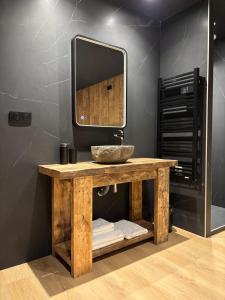 een badkamer met een houten wastafel en een spiegel bij L'Oxalis villa, l'Edelweiss in Bonnelles