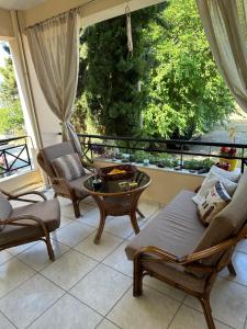 a living room with chairs and a table and a window at Athina in Nea Peramos