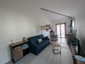 a living room with a blue couch and a table at Studio Verthier in Doussard