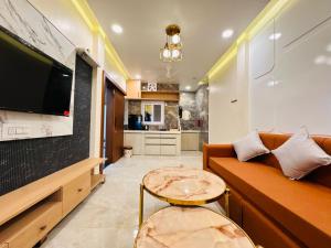 a living room with a couch and a tv and a table at Shrilok Kutir 1BHK Penthouse in Ujjain