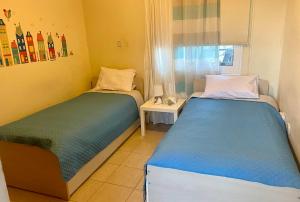 two twin beds in a room with a window at Sea View Penthouse in Larnaca +19 photos