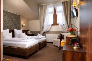 una habitación de hotel con dos camas y un sofá en Amber Boutique Hotels - Amber Design, en Cracovia