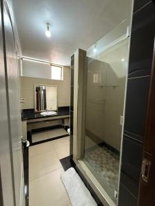 a bathroom with a shower with a sink and a mirror at CapePod City Centre in Cape Town