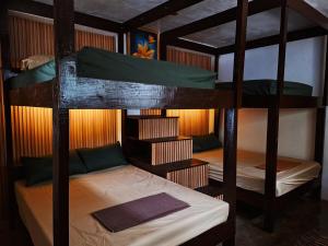 Balay Karajaw Island Home 12pax في جنرال لونا: سريرين بطابقين في غرفة مع سرير