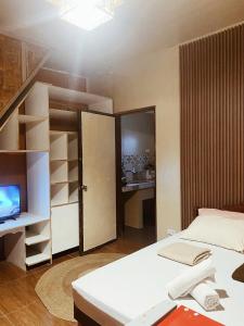 Un dormitorio con una cama y un televisor y una habitación con un armario. en Balay Karajaw Island Home 12pax, en General Luna 13 fotos más