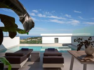 a house with a swimming pool with a table and chairs at Hotel St.John Suites Adults Only in Tsilivi