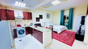 ドバイにあるYour Perfect 1BHK Apartmentのキッチン(赤いキャビネット付)、