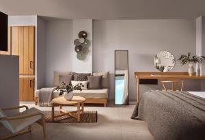 a bedroom with a bed and a couch and a table at Hotel St.John Suites Adults Only in Tsilivi