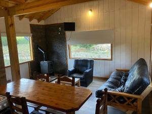 a living room with a couch and a table at Casa de la ventana in Lago Meliquina