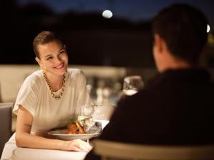 a woman sitting at a table with a plate of food at Hotel St.John Suites Adults Only in Tsilivi