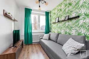 een woonkamer met een bank en groene gordijnen bij Stylish Studio Oldtown in Gdańsk