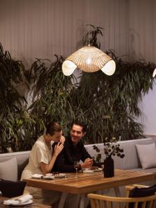 a man and a woman sitting at a table at Hotel St.John Suites Adults Only in Tsilivi