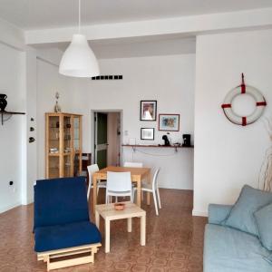 a living room with a table and a blue couch at M335 Marcelli, ampio bilocale fronte mare con balcone in Marcelli