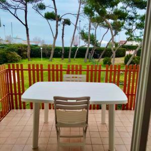 a white table and two chairs on a patio at M335 Marcelli, ampio bilocale fronte mare con balcone in Marcelli +11 photos