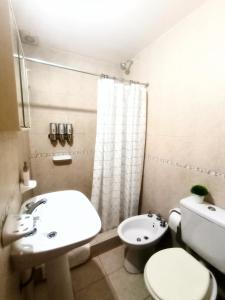 a bathroom with a white toilet and a sink at Duplex Echesortu a metros de la terminal in Rosario