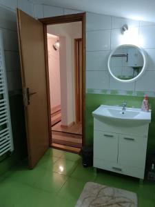a bathroom with a white sink and a mirror at Goražde-Centar Apartment in Goražde +30 photos