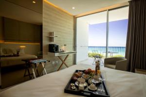 a hotel room with a tray of food on a bed at Posia Retreat & Spa UNA Esperienze in San Foca