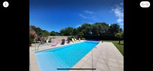 a large swimming pool in a yard with a house at Villa de charme LA ROCHE AUX LIONS in Archigny +10 photos
