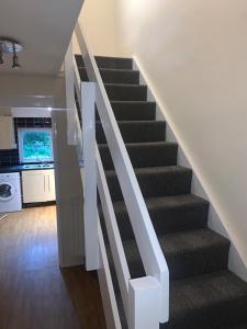 escalera en una sala de estar con cocina en Lovely Milton Keynes Double Room, en Milton Keynes