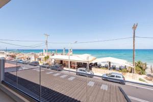 a view of the beach from a balcony with cars parked at Dimitra Hotel & Apartments by Omilos Hotels in Kokkíni Khánion
