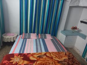 a small bed in a room with a curtain at Prayagraj Sangam Stay Home Kareli Allahabad in Prayagraj