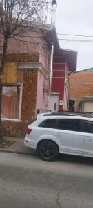 eine weiße Limousine, die vor einem Haus parkt in der Unterkunft Small apartment with private bathrooms STRONG INTERNET in Belgrad