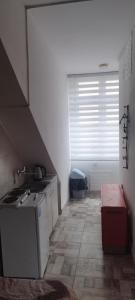 eine kleine Küche mit Spüle und Fenster in der Unterkunft Small apartment with private bathrooms STRONG INTERNET in Belgrad