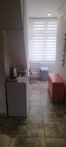 Zimmer mit einer Küche mit einem Tisch und einem Fenster in der Unterkunft Small apartment with private bathrooms STRONG INTERNET in Belgrad