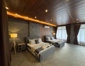 a bedroom with two beds and a couch in it at De Monarch, penthouse in Bolinao