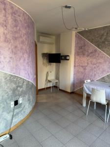 a room with a table and chairs and a tv at Michelle Luxury Living in centro a Gorizia in Gorizia