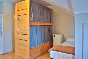 a bedroom with a wooden bunk bed with a window at Casa Gaea Stay in Braga