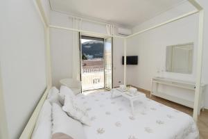 een witte slaapkamer met een bed en een raam bij Appartamento Corso Italia 38 C in Sorrento