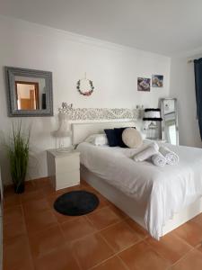 a bedroom with a white bed and a mirror at Circus-Goretti House in Mairena del Aljarafe