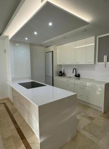 Una cocina con gabinetes blancos y una encimera blanca. en Dream home Beny, en Palm-mar