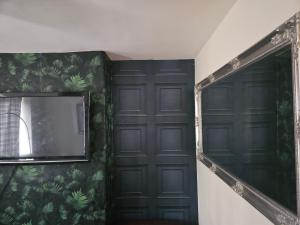 Cette chambre dispose de deux portes noires et d'un miroir. dans l'établissement Mama jos, à Manchester