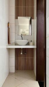 a bathroom with a sink and a mirror at Cop 30 home with garden and lake in Belém