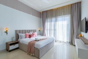 a bedroom with a large bed with pink pillows at ELIVAAS Shourya Sereno - Luxe 4 BHK Villa With Pvt Pool & Garden in Lakāwās