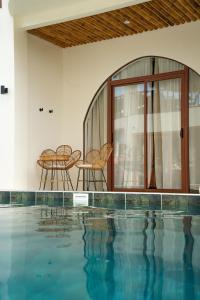 a swimming pool with two chairs and a table at Moana Dive Resort in Panglao Island