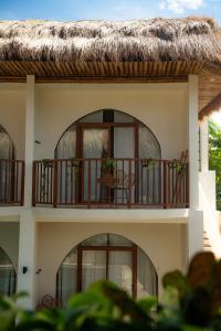 a building with a balcony with a thatched roof at Moana Dive Resort in Panglao Island
