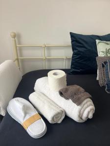 a pile of towels and a roll of toilet paper on a bed at Mex-Goretti House in Mairena del Aljarafe