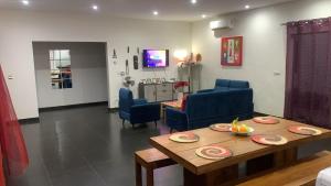 a living room with a table and blue chairs at Keur Lola quartier aigrettes in Somone